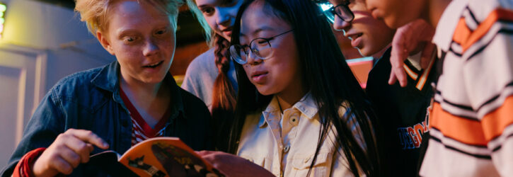 group of teenagers looking at a brochure