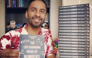 Bobby Seagull holding a copy of his book The Life-Changing Magic of Numbers