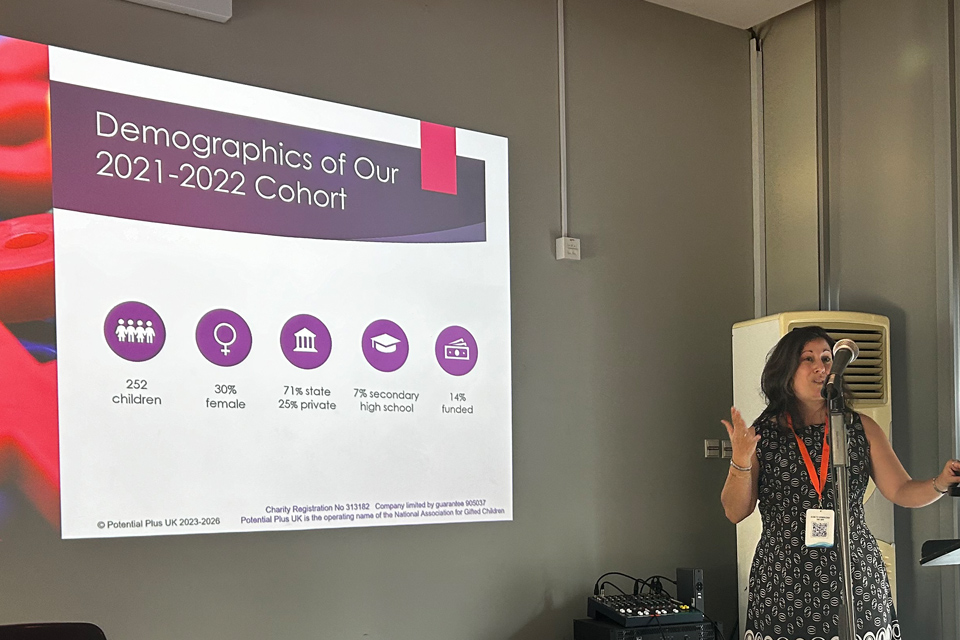 Andrea Anguera presenting a talk in front of a slide with statistics on it, at the ECHA Conference 2024