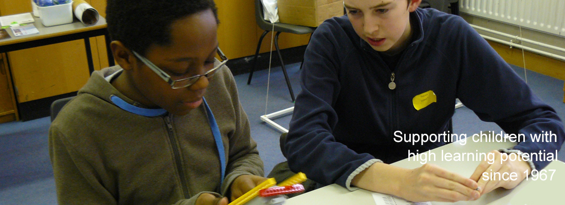 Two teenage boys working in a classroom on a construction project. Wording: supporting children with high learning potential since 1967